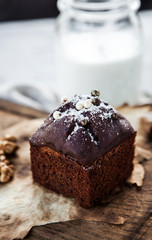 Chocolate cake or brownie on a wooden board with a bootle of milk
