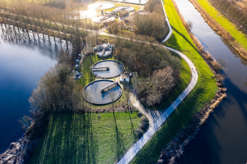 A dutch water treatment plant for cleaning the sewage water, seen from above during sunset. Near Waalwijk, Noord-Brabant, Netherlands. - obrazy, fototapety, plakaty