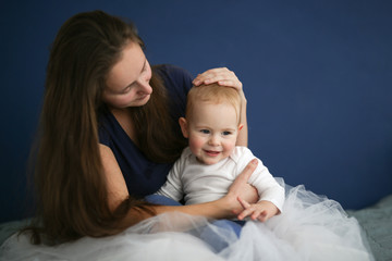 mom holds the baby in her arms, blue background