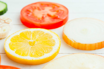 Sliced fruits, vegetables on white wooden table