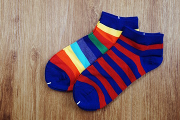 Flat lay pair of colorful socks on wooden background