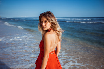 Portrait of a sexy girl on the Beach in a red dress