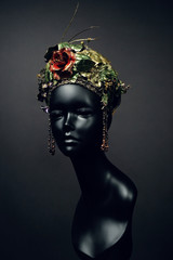 Head of mannequin in creative kokoshnick with flower and leaves