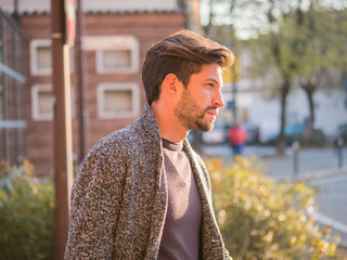 One handsome young man in urban setting in European city, standing
