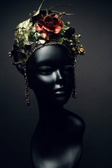 Head of mannequin in creative kokoshnick with flower and leaves