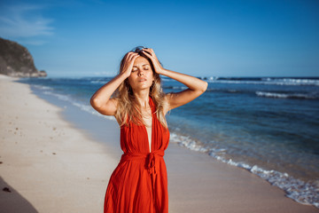 Fototapeta na wymiar Girl holding her head on the beach suffering from the heat