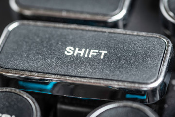 An extreme close-up or macro shot of a rectangular SHIFT key on a vintage-inspired retro-style clicky black-and-silver metal typewriter keyboard.