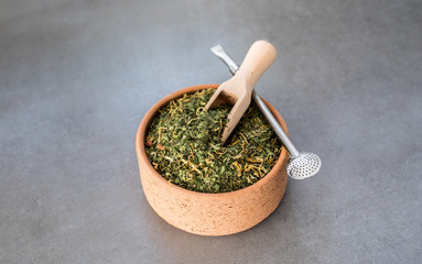 Traditional Yerba Mate tea with matero and bombilla, healthy, energy boosting beverage drink on neutral stone gray background.