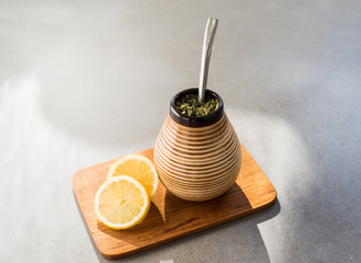 Traditional Yerba Mate tea with matero and bombilla, healthy, energy boosting beverage drink on neutral stone gray background.