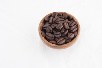 Stack of coffee beans in wooden bowl