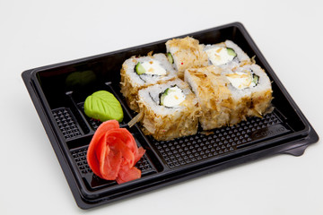 Japanese traditional cuisine, ready-made rolls and sushi in the package, on a white background, for the application and design of fast-food