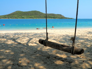 Beach with sea, mountain, sands, and swing in sunny day photo. Traveler are happy on vocation in the ocean. It is Samae San Island, Chonburi Province, Thailand, Asia.