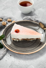Strawberry souffle cake slice on a gray plate with a cup of tea