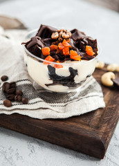 Chocolate dessert brownie with dried apricots and nuts in a cup