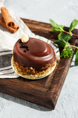 Chocolate mousse dessert pudding with nuts and cinnamon on a wooden board