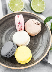 Spring composition of different colorful macaroons on a gray concrete background