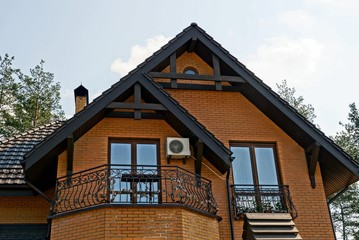 part of a brown private house with windows and a roof against the sky