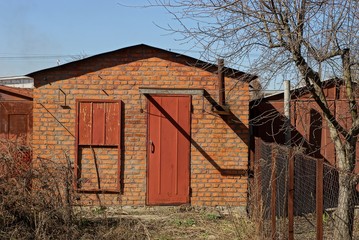 old brown brown barn with a red door in the yard