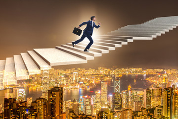 Businessman climbing career ladder over city