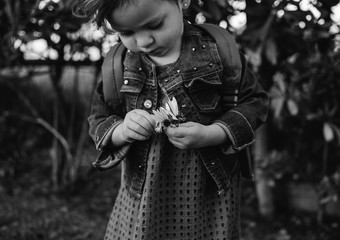 Niña pequeña con una flor en la mano
