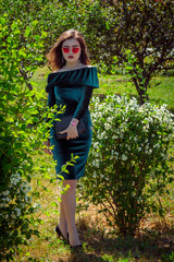 Portrait of beautiful young brunette woman with bright makeup, wearing emerald green velvet dress...
