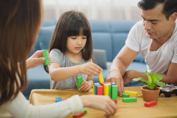 Family time Daughter laughing enjoying playing with her parent on the table in front of sofa at...