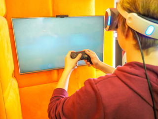 Teenager playing video game. blank white screen. place for your layout on the TV. Hands holding console controller. VR headset. © Evgeniy