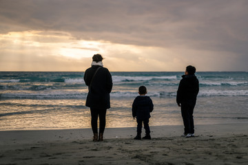 Trois personnes regardant la mer pars une soirée nuageuse, tyr, liban
