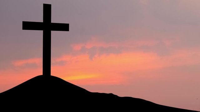 Time lapse of silhouette of a cross symbol on the hill at dusk time. Shot in 4k resolution