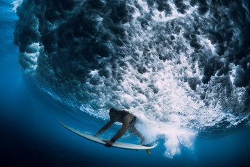 Attractive surfer woman dive underwater with under big wave.