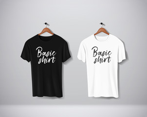 Basic Black and white short sleeve T-Shirts Mock-up clothes set hanging isolated on wall. Front side view with lettering for your design or logo.