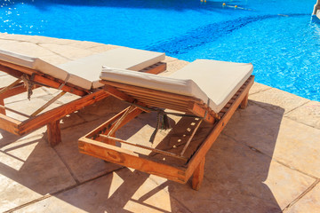 Chaise longues near a swimming pool. Concept of spa, rest, relaxation, holidays, resort