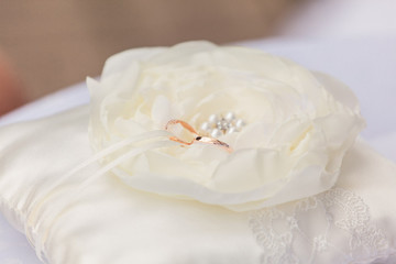 Wedding rings on cream pillow