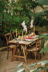 Table and chairs in a tropical garden before the wedding dinner