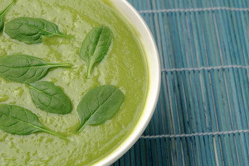 Healthy cream soup of green vegetables, sprinkled with spinach leaves