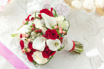 Wedding bouquet of roses and callas on the table of Candy Bar