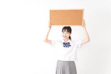 コルクボードを持つ学生
