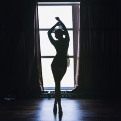 Slim woman silhouette over large panoramic window