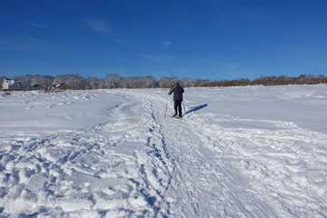 Skier on a walk on a snowy field. Ski walk. Beautiful winter day.