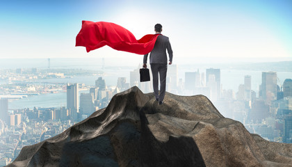 Superhero businessman on top of mountain