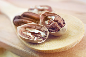 pecan close-up macro high resolution on wooden background, toned