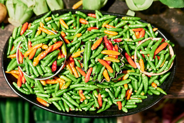 Close-up of plenty small green and red chili placed on a plate, with small ready to buy portions, for sale in Chinatown, Manila, Philippines