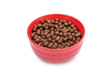 Red bowl with chocolate corn balls on a white background. Top view.