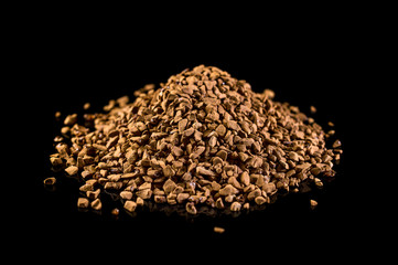Heap of instant coffee on black.