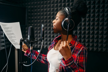 Young woman songs in audio recording studio