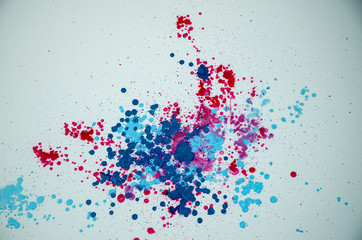 Red and blue color powder exploding on white background