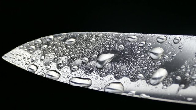 Chef's knife close-up. Knife santoku. blade blade. Drops of water flow down the blade of a knife. Cut vegetables. Cook lunch. Reflection of cold weapons.