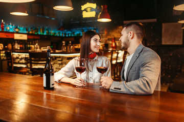 Man and woman flirting in bar, romantic evening