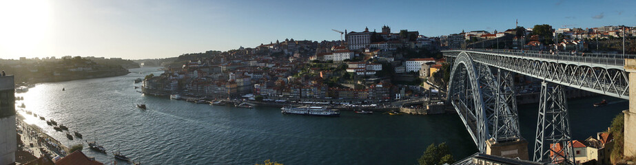 Fototapeta na wymiar malerische Häuser und Schiffe am Douro und der Brücke Ponte Dom Luís I in Porto / Portugal - Panorama