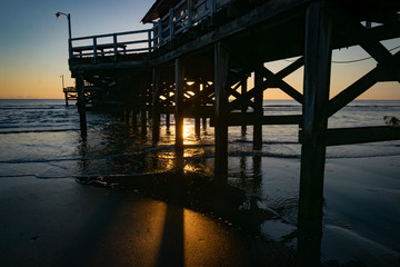 Fototapeta na wymiar Muelle al amanecer en la playa